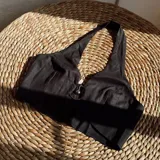 Top negro con escote halter y abertura en el centro del busto con detalle de argolla metálica.