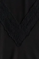 Top entallado de punto acanalado negro, con mangas cortas y escote en V pronunciado ribeteado con encaje.