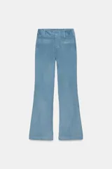 Pantalón de tiro alto con corte flare, confeccionado en pana. Presenta cintura ancha con trabillas, falsos bolsillos delanteros y cierre frontal con cremallera, botón oculto y ganchos metálicos.