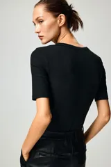 Remera negra de punto acanalado con cuello redondo y mangas cortas.