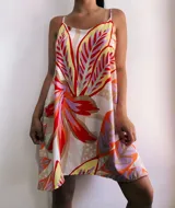 Vestido corto con estampado de hojas en tonos rojo, naranja, amarillo, lila y beige. Tiene tirantes finos y corte suelto.