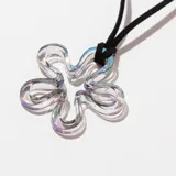Collar con dije de vidrio transparente en forma de flor de cinco pétalos y cordón negro.