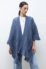 Ruana de punto color azul con estampado de espiga en dos tonos de azul, diseño holgado, con bolsillos y flecos en el borde inferior.