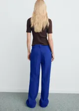 Pantalón de tiro medio color azul, con diseño recto y largo, trabillas para cinturón y cierre oculto con botón, gancho y cremallera.
