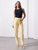 Pantalón de lino color beige, marca Zac & Rachel, con pretina ancha, pasadores y lazo de ajuste. Presenta bolsillos delanteros aplicados.