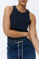 Musculosa de algodón en punto acanalado, color negro, con cuello redondo y diseño ajustado sin mangas.