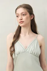 Camisón de pijama negro de tejido satinado con leve elasticidad, escote en V, recorte bajo busto y tiras finas regulables.