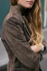 Blazer cruzado de mujer, color marrón oscuro, confeccionado en piel 100%. Presenta cuello solapa, manga larga con hombreras, bolsillos delanteros de doble vivo y cierre frontal cruzado con botones oscuros.