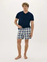Pijama de hombre compuesto por una remera azul marino de cuello V y un short a cuadros en tonos azul, blanco y gris.
