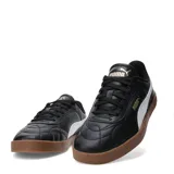 Championes urbanos Puma modelo Club II Indoor, color negro con detalles en blanco y suela de goma color caramelo. Presentan un diseño acolchado en la puntera y logo de la marca en dorado.