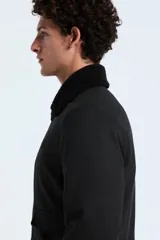 Campera tipo bomber color gris oscuro, con cuello de sherpa negro, cierre frontal con botones y bolsillos laterales con solapa. Presenta puños y ruedo de tejido elástico.