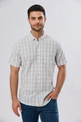 Camisa de manga corta confeccionada en mezcla de lino y algodón, con diseño a cuadros en tonos gris, blanco y azul. Presenta cuello camisero con botones y bolsillo ojal en el pecho con detalle bordado.