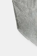 Top de escote asimétrico con un solo tirante ancho, confeccionado en tejido con aplicación de brillos plateados. Presenta un diseño de un solo hombro y bajo asimétrico acabado en punta tipo pañuelo.