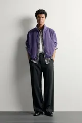 Cazadora relaxed fit de algodón en color violeta, con efecto lavado, cuello subido, cierre frontal con cremallera y bolsillos de vivo en la cadera.
