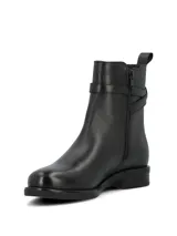 Bota baja de cuero color negro, con caña media, puntera redonda, elástico lateral y tira decorativa con hebilla metálica.