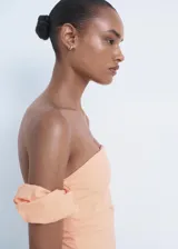 Vestido midi color salmón, de corte entallado con diseño palabra de honor, mangas cortas caídas abullonadas y tajo lateral en la falda.