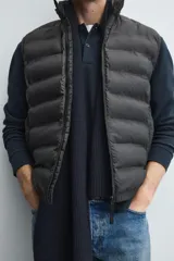Chaleco acolchado de hombre color negro, con diseño puffer, cuello alto y cierre frontal con cremallera.