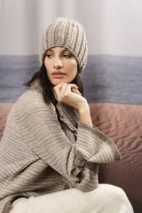 Gorro tejido a mano en punto grueso, con diseño de canalé y textura jaspeada en tonos neutros.