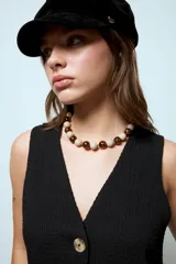 Collar corto de cuentas esféricas de resina, alternando colores crema y estampado animal print tipo leopardo.