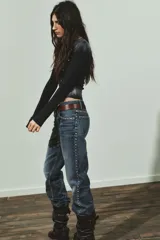 Camiseta de manga larga color negro con efecto lavado, cuello barco y detalle de tachas plateadas distribuidas por todo el frente.