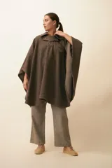Poncho de lana fina sin teñir color marrón, con cuello, cartera con broches a presión y un bolsillo ojal en el pecho. Diseño campestre y unisex.