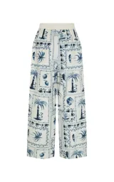 Pantalon ancho de tiro alto de Le Lis Blanc con estampado de palmeras y motivos tropicales en azul y blanco.