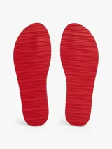 Ojotas de hombre color azul marino con tiras de textil trenzado que llevan el logo de Tommy Hilfiger en jacquard blanco. La suela es de EVA dentada con entresuela a contraste en blanco y rojo.