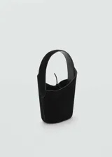 Bolso de mano tipo bucket en color negro, confeccionado en piel con acabado aterciopelado. Presenta un diseño minimalista con asa superior integrada y cierre mediante lazo ajustable en la parte central.