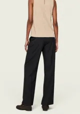 Pantalón sastrero negro de corte recto y tiro alto, con pinzas delanteras y bolsillos laterales.