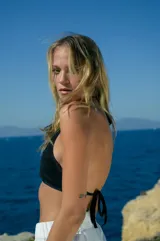 Top negro de tela de toalla con tiras de tricot a tono, regulable en cuello y espalda.