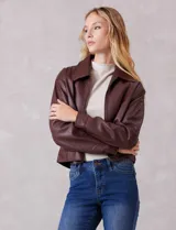 Campera de eco cuero color bordó, con cuello camisero, cierre frontal metálico y bolsillos laterales. Presenta un diseño de corte recto y forro interno a tono.