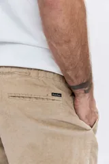 Pantalon de corte recto confeccionado en pana color beige, con cintura elástica y cordón ajustable.