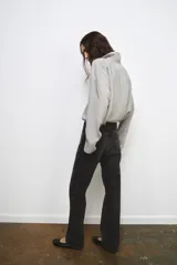 Jeans de tiro medio y corte recto, confeccionados en algodón con efecto lavado en tono gris oscuro. Presentan cintura con trabillas, cierre frontal con cremallera y botón, y diseño clásico de cinco bolsillos.