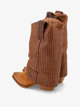 Bota de caña media con diseño de punta fina y taco ancho. Presenta una caña alta con un tramado tejido en cuero y una base de gamuza negra.