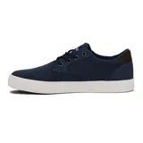 Zapatillas acordonadas de lona azul con suela blanca y detalles en cuero marrón en el talón.