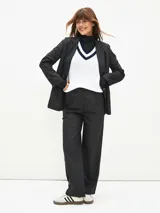 Pantalón negro de vestir con finas rayas verticales blancas, corte recto y tiro alto.