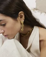 Aros colgantes de diseño orgánico con textura irregular, compuestos por tres piezas eslabonadas en acabado dorado. Incluye un earcuff a juego de diseño minimalista.