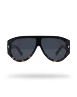 Lentes de sol con armazón carey y negro, de diseño envolvente y estilo máscara, con detalles metálicos dorados en las patillas.