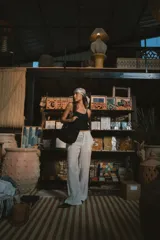 Pantalón de corte recto y tiro alto, confeccionado en tejido de lino, con bolsillos laterales y cierre frontal con botón y cremallera.