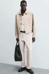 Pantalón chino de corte regular fit, confeccionado en tejido de algodón con elasticidad. Presenta bolsillos frontales, bolsillos traseros de vivo y cierre frontal con cremallera y botón.