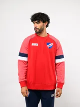 Buzo de cuello redondo del Club Nacional de Football, color azul marino con mangas grises y franjas rojas y blancas en los brazos. Incluye el escudo del club en el pecho y logos de Umbro y BBVA.