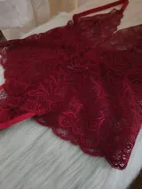Body de encaje color rojo con escote pronunciado, breteles regulables y diseño tipo tanga en la parte inferior.