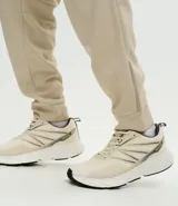 Pantalón deportivo de corte ajustado, confeccionado en tejido de poliéster texturizado color negro. Presenta cintura elástica con cordón de ajuste, bolsillos laterales con cierre y puños elásticos en los tobillos.