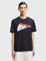 Remera Moncler de algodón color azul oscuro, con cuello redondo, manga corta y gran estampado gráfico frontal con el nombre de la marca en tonos blanco y rojo.
