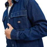 Camisa de denim azul con dos bolsillos frontales con botón y logo de la marca en uno de ellos.