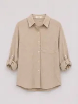 Camisa de manga larga con cuello camisero, confeccionada en algodón con textura geométrica en relieve. Presenta cierre frontal con botones, un bolsillo en el pecho y mangas con sistema de ajuste mediante trabilla y botón.