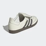 Championes Adidas Samba LT color crema con las tres tiras laterales negras con costuras en forma de equis. Suela de goma marrón.