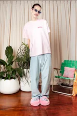 Remera celeste de algodón con logo de la marca Tranca estampado en rosa en el pecho.