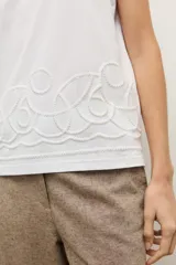 Musculosa cruda de corte recto y sin mangas, con cuello redondo y diseño estampado en relieve en el borde inferior.