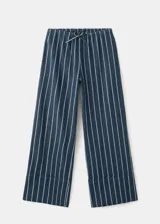 Pantalón de corte recto y tiro regular, confeccionado en algodón con diseño de rayas verticales. Presenta cintura elástica con cordón ajustable y bolsillos laterales.